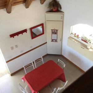 圣拉斐尔Casa en Los Reyunos, Ubicación perfecta Frente al lago的厨房配有红色的桌椅和冰箱。