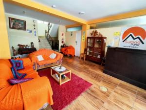 普诺SUMAQ PUNO的客厅配有橙色沙发和舞台