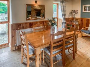 斯泰兹Seaton Cottage - Uk31990的一间带木桌和椅子的用餐室