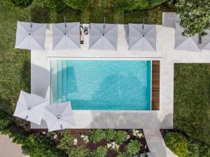 科涅克La Nauve, Hôtel & Jardin - Relais & Châteaux的享有带遮阳伞的游泳池的顶部景致