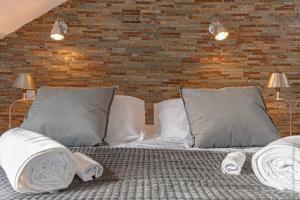 里摩日Les suites locarno的一间卧室配有带枕头的床和砖墙