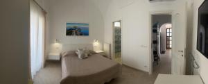 阿纳卡普里Caprita Guest House的一间卧室配有一张带两盏灯和镜子的床