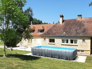 萨尔拉拉卡内达Manoir Petit Meysset的一座房子前面设有游泳池
