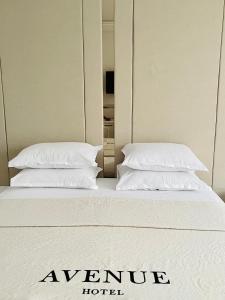拉夫达Hotel AVENUE的在酒店客房的床上放两个枕头
