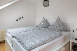 布莱特瑙Weitblick的白色卧室配有带灰色枕头的床
