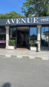 拉夫达Hotel AVENUE的前面有标牌的商店