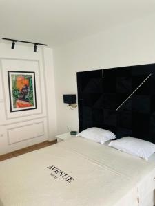 拉夫达Hotel AVENUE的一张床上,上面有黑色床头板