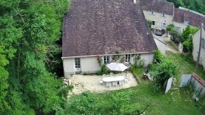TrézanLe Moulin,19 bis rue de Beaudon, 45330 Augerville la riviere的享有带桌子和雨伞的房子的顶部景色
