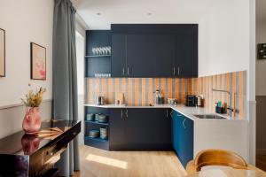 巴黎Edgar Suites Montmartre - Paul Albert的厨房配有蓝色橱柜和水槽