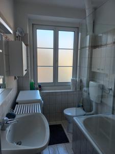 格拉茨圣莱昂哈德公寓的浴室配有盥洗盆、卫生间和浴缸。