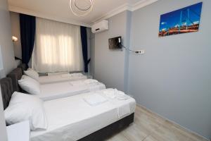 伊斯坦布尔Merdin Suites & Hotel - Downtown的配有窗户的酒店客房内的两张床