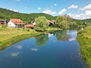 奥托查茨Kuća za odmor Klasan的一条有房屋和树木的河流