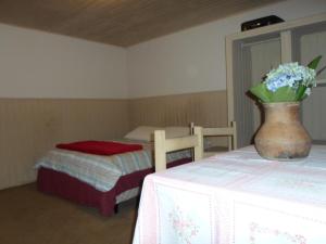 坎波斯杜若尔当索佳木屋的一间设有两张床的房间和一个花瓶,摆放在桌子上