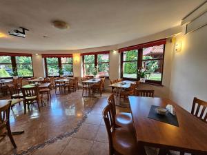 波兰尼卡-兹德鲁伊Villa Alexandra的餐厅设有木桌、椅子和窗户。