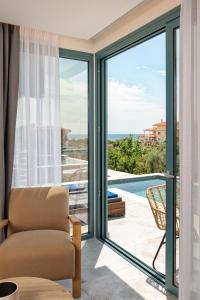 利迈纳里亚Villa Gonates的客厅设有滑动玻璃门,享有游泳池的景色