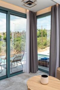 利迈纳里亚Villa Gonates的客厅设有滑动玻璃门和桌子