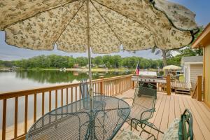 雷克Waterfront Lake Cabin Close to Boating and Fishing!的甲板上的桌椅和遮阳伞