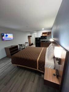 钱诺夫Relax Inn Channelview的酒店客房设有一张大床和一个厨房。