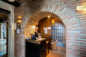 瓜迪克斯YIT阿本托菲儿酒店的砖砌走廊,配有书桌和笔记本电脑