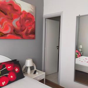 圣伊西多罗B&B Al Melograno的卧室配有一张床,墙上挂有绘画作品