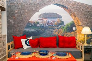 伊兹拉Ydor apartment的一张带红色枕头的沙发和壁画墙