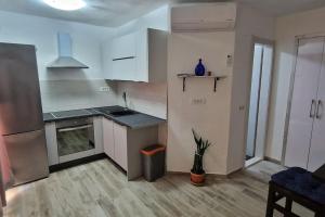 尼库加姆Apartments Belvedere - A4的厨房配有白色橱柜和盆栽植物