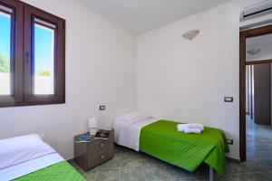 洛特佐拉伊5 - Relax e comfort in casa con giardino - Sa Crai Apartments Sardinian Experience的一间卧室设有两张床和窗户。