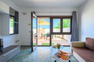 洛特佐拉伊5 - Relax e comfort in casa con giardino - Sa Crai Apartments Sardinian Experience的客厅配有沙发和桌子