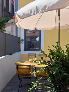 波尔图Boavista Luxury Villas的露台配有遮阳伞和桌椅