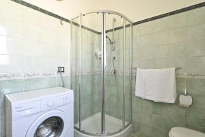 洛特佐拉伊5 - Relax e comfort in casa con giardino - Sa Crai Apartments Sardinian Experience的带淋浴和洗衣机的浴室