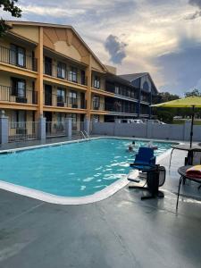 莫比尔提尔曼斯角Days Inn & Suites Mobile的酒店前的游泳池