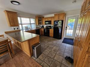 圣约翰Douglas Lake Paradise B的厨房配有木制橱柜和黑色冰箱。