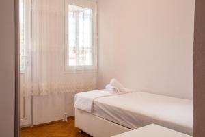 伊兹密尔Flat with Large Balcony in Izmir的白色的客房设有两张床和窗户。