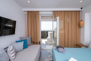 佩里沃罗Sand Gem - Beach Apartments的一间卧室配有一张床、一张沙发和一个窗口