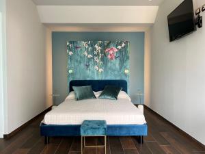 切塞纳蒂科Le Finestre Sul Lago的卧室配有一张蓝色的床,墙上挂着一幅画