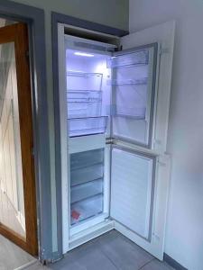 达灵顿Comfy Darlington Home的空冰箱,门打开在房间里