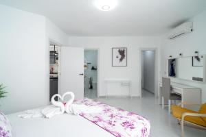 内尔哈Casa Higuera的一间白色的卧室,配有一张带弓的床铺