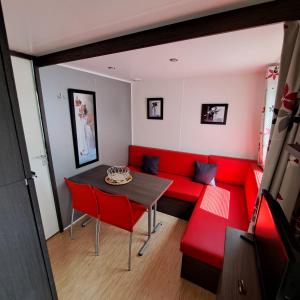 拉皮隆尼尔Mobile home à louer Les Sables d'Olonne - Vendée的客厅配有红色的沙发和桌子