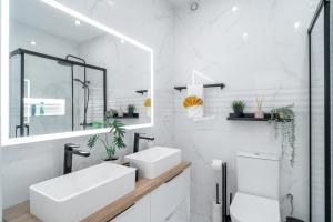 内尔哈Casa Higuera的白色的浴室设有2个盥洗盆和1个卫生间。