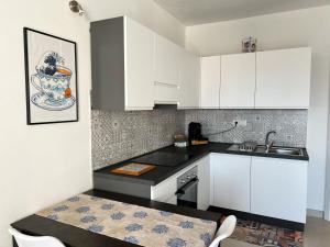托里格兰德Sunnyside Apartment的厨房配有白色橱柜、水槽和桌子