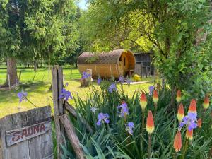 利梅伊Camping La Ferme de Perdigat的鲜花盛开的花园,木棚