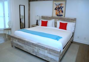 南安普敦Harpoon House的一间卧室配有一张大木床,提供红色和蓝色的枕头