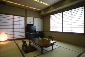 熊谷金大使熊谷酒店的一间带桌椅和窗户的用餐室
