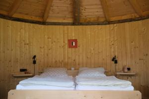 芬肯施泰因Holzjurten by JULKA - self checkin的卧室配有木墙内的两张床