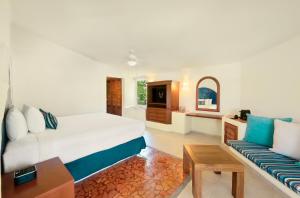 莫雷洛斯港Desire Riviera Maya Pearl Resort All Inclusive - Couples Only的一间卧室配有一张大床和一张沙发