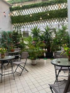 那不勒斯Monteoliveto 33的一个带桌椅和盆栽的庭院