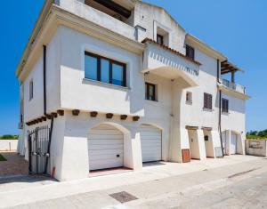 洛特佐拉伊6 - Meraviglioso appartamento con terrazza - Sa Crai Apartments Sardinian Experience的两扇车库门的白色房子