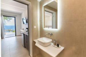 帕尔加Lithitsa Lofts and Suites的一间带水槽和镜子的浴室
