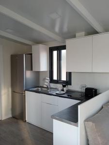 阿桂拉斯Bungalow Duemo Camperpark的厨房配有白色橱柜和不锈钢冰箱