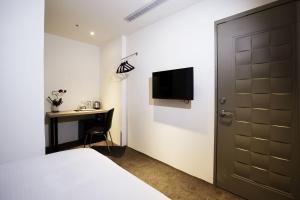 台北皇后旅店二馆的一间卧室配有一张床、一张书桌和一台电视